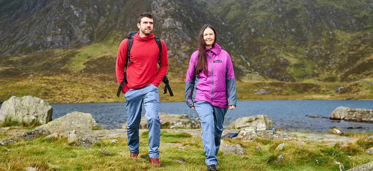 Man hiking by a lake in Snowdon with his wife