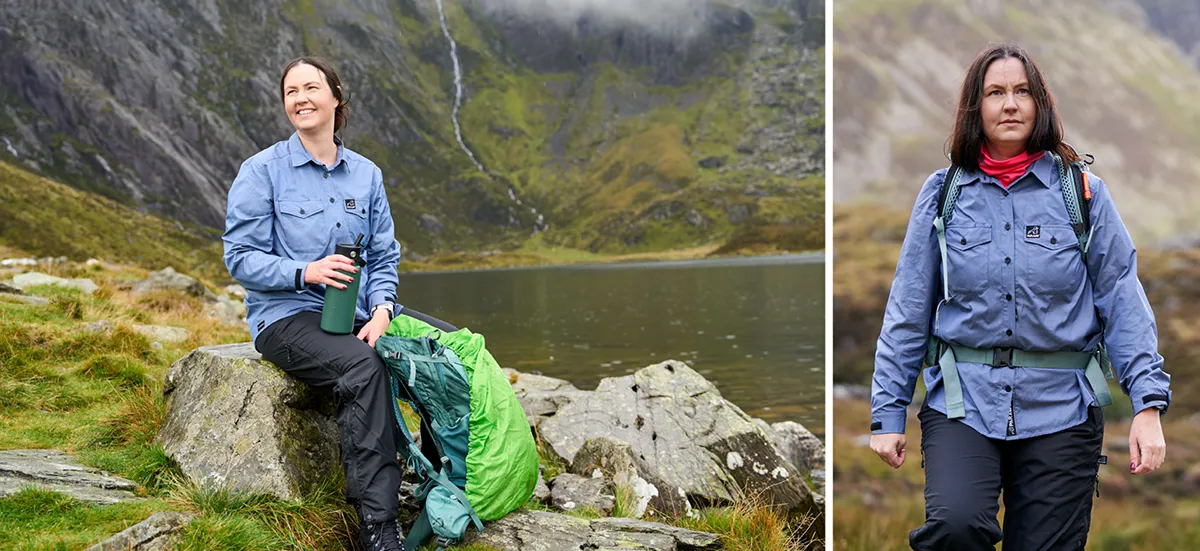 Woman wearing blue outdoors shirts sitting on a rock by a lake nestled in the mountains