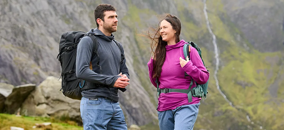 Woman wearing warm top with backpack, relaxing with her husband